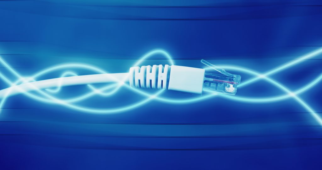 A close up of network cables against a blue background and illustrated energy around the cable